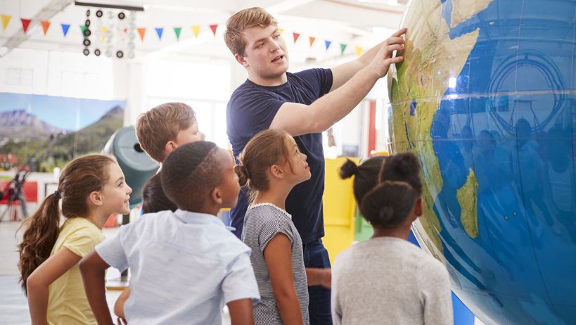 Teacher shows kids giant globe